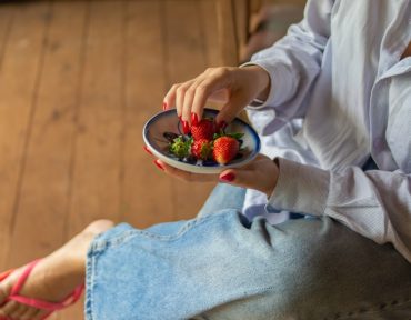 Fresh strawberries served in a ceramic bowl, capturing a simple and healthy lifestyle moment in a rustic countryside setting.