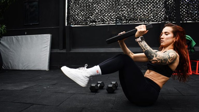 A determined woman performs a core workout in an indoor gym setting.